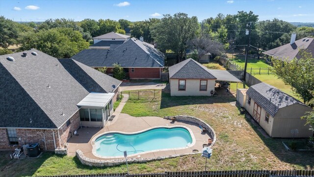 view of pool with a lawn, a patio area, and a shed