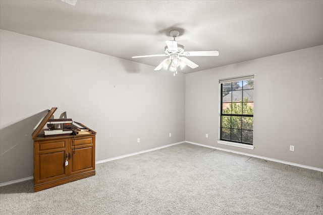 empty room with ceiling fan and light colored carpet