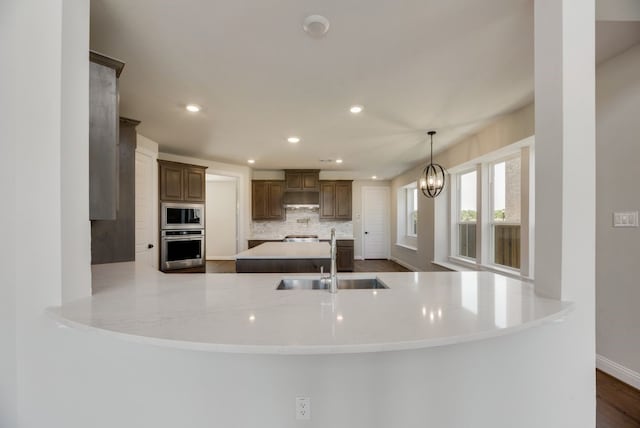 kitchen with appliances with stainless steel finishes, recessed lighting, a sink, and backsplash