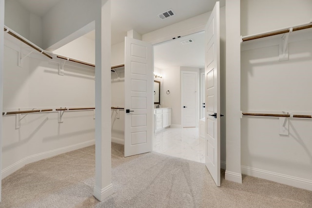 walk in closet featuring light colored carpet