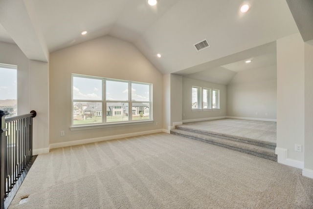 unfurnished living room with light carpet and vaulted ceiling