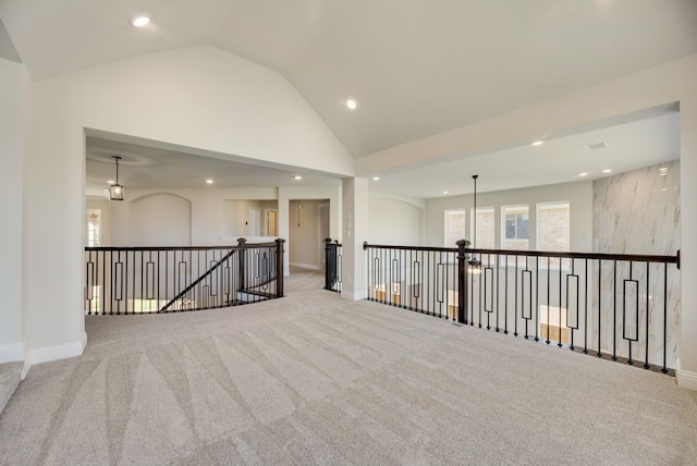 carpeted empty room featuring high vaulted ceiling, recessed lighting, and baseboards