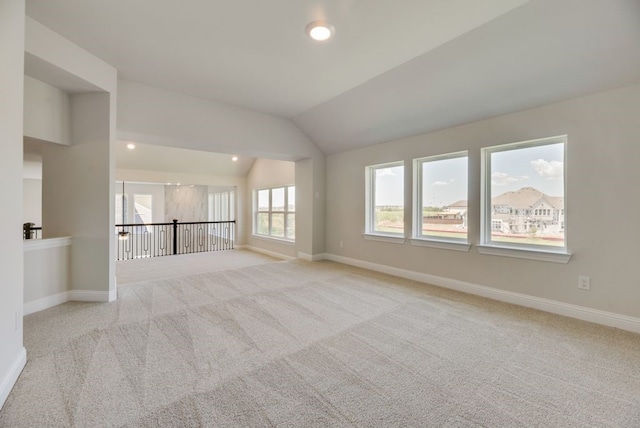 carpeted empty room with lofted ceiling, baseboards, and recessed lighting