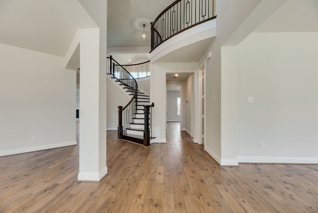 foyer featuring a towering ceiling and light wood-type flooring