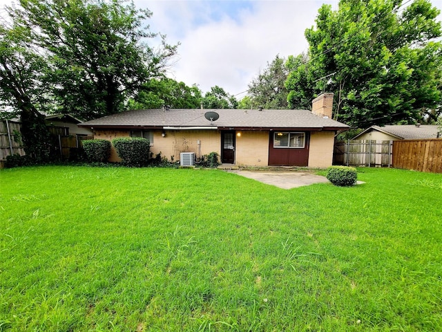 rear view of property with a lawn, a patio, and central air condition unit