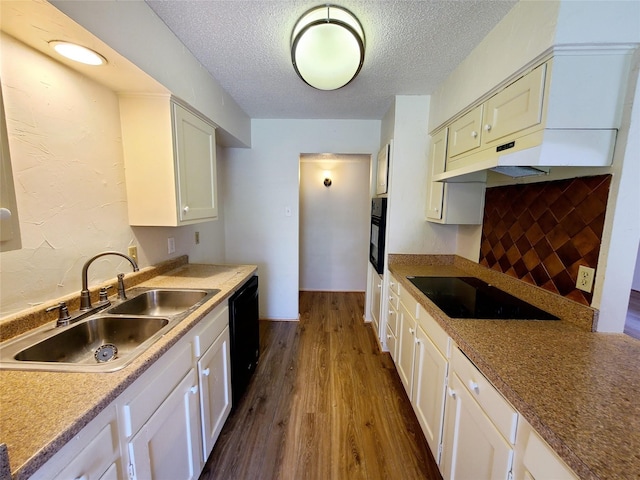 kitchen with a textured ceiling, dark hardwood / wood-style flooring, black appliances, sink, and white cabinets