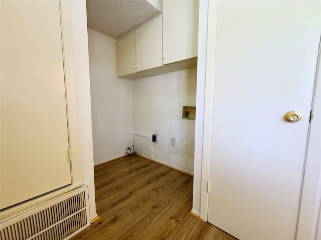 laundry room featuring hookup for a washing machine, light hardwood / wood-style flooring, cabinets, and electric dryer hookup