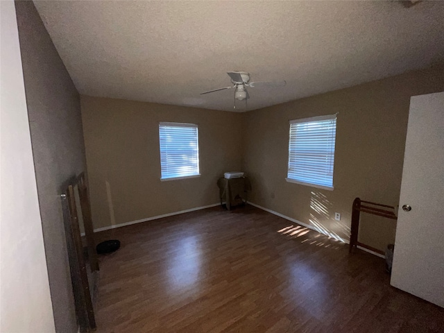 empty room featuring ceiling fan, a textured ceiling, and dark hardwood / wood-style flooring