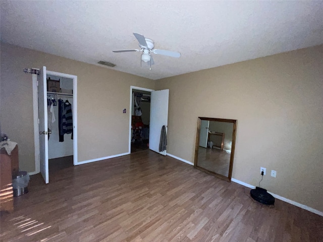 unfurnished bedroom with ceiling fan, hardwood / wood-style flooring, and a closet