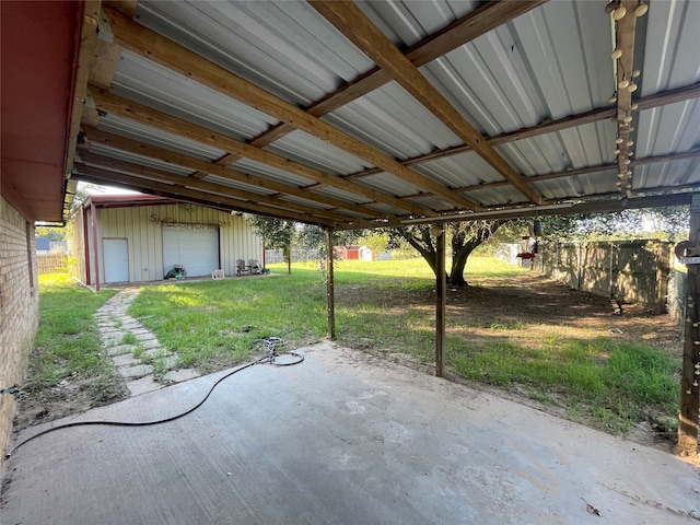 view of patio / terrace with a garage and an outbuilding