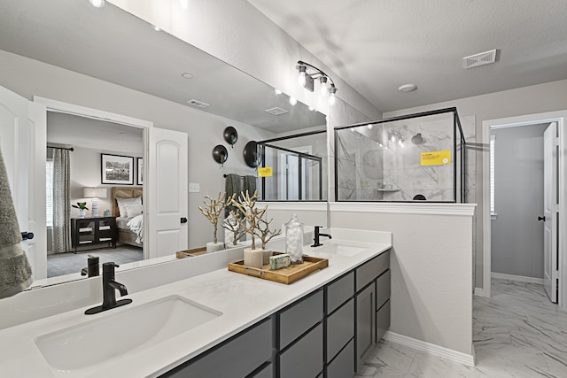 bathroom featuring vanity, a shower with shower door, and a textured ceiling