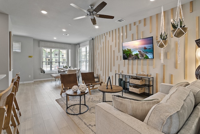 living room featuring ceiling fan and light hardwood / wood-style flooring