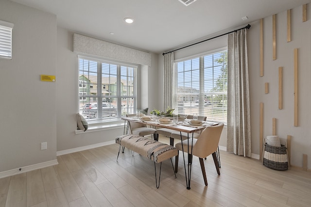 dining area with light hardwood / wood-style flooring and a healthy amount of sunlight