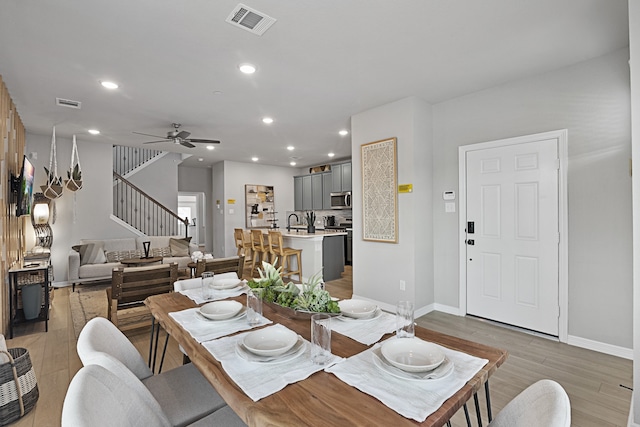 dining room featuring ceiling fan, light hardwood / wood-style flooring, and sink