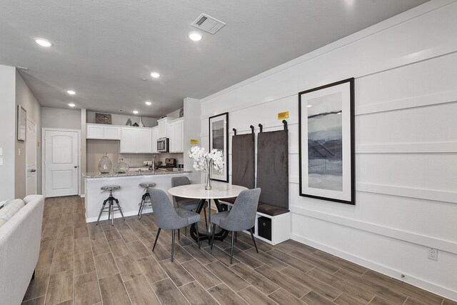 living room with a textured ceiling, ceiling fan, and hardwood / wood-style floors