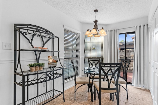 dining room with light tile patterned floors, a notable chandelier, and a textured ceiling