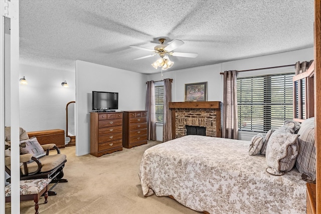 carpeted bedroom featuring a brick fireplace, a textured ceiling, and ceiling fan