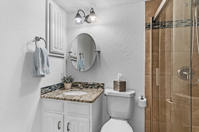 bathroom with tiled shower, vanity, a textured ceiling, decorative backsplash, and toilet