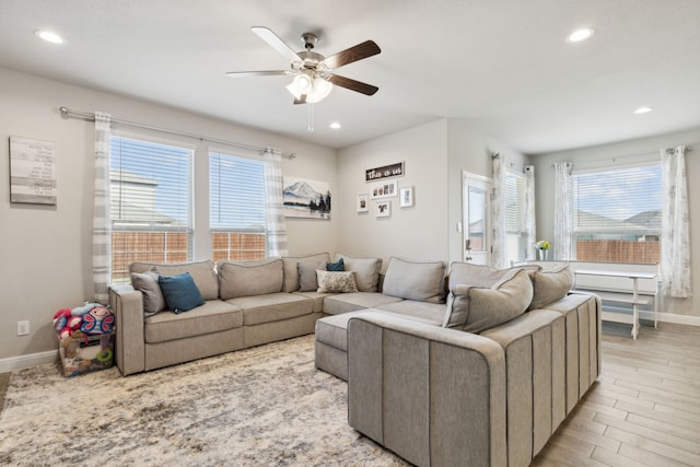 living room featuring light hardwood / wood-style floors and ceiling fan