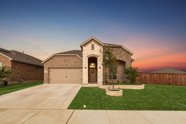 french provincial home featuring a garage and a lawn