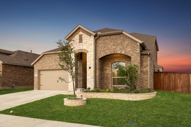 view of front of property with a garage and a lawn