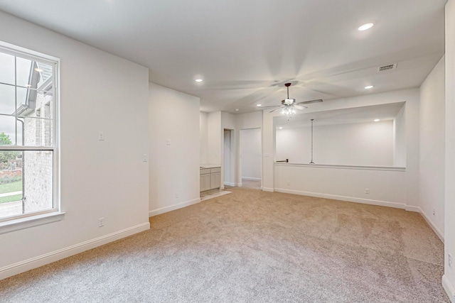 spare room with ceiling fan and light carpet