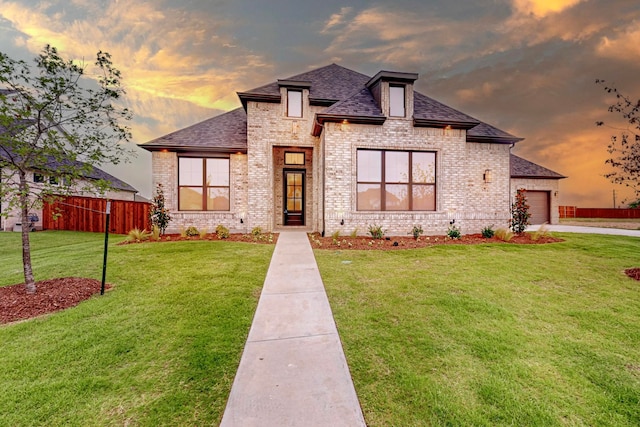 view of front of home with a garage and a lawn