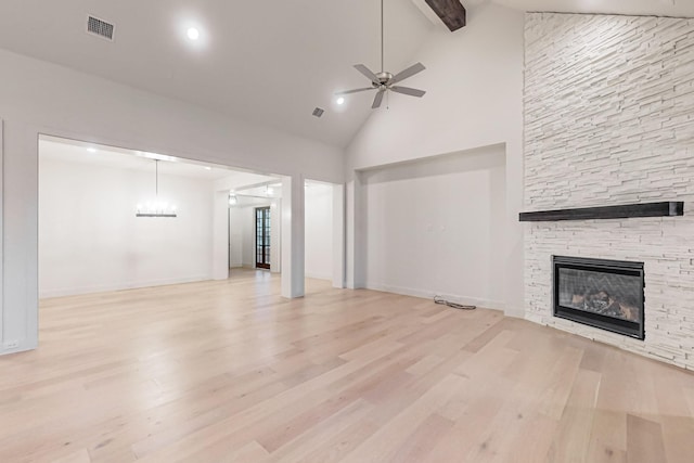 unfurnished living room with light wood finished floors, ceiling fan, a fireplace, and visible vents