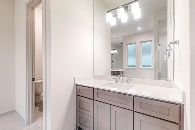 bathroom with walk in shower, vanity, toilet, and tile patterned floors