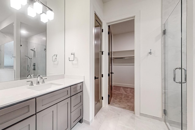 full bathroom featuring a shower stall, a spacious closet, and vanity