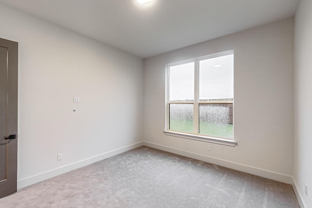 unfurnished room with light carpet and baseboards