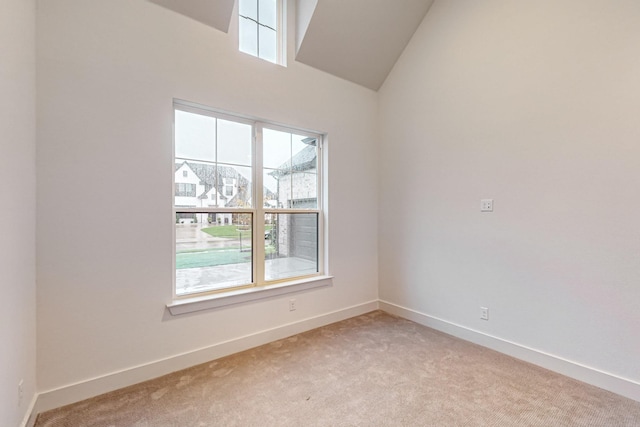 spare room with baseboards and light colored carpet