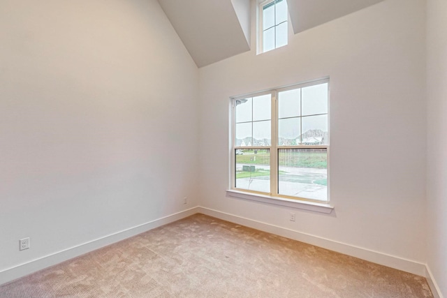 carpeted empty room with high vaulted ceiling and a wealth of natural light