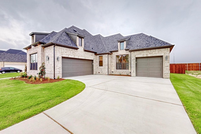 french provincial home featuring a front yard and a garage