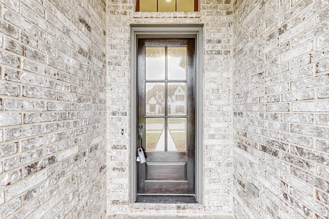 entrance to property featuring brick siding