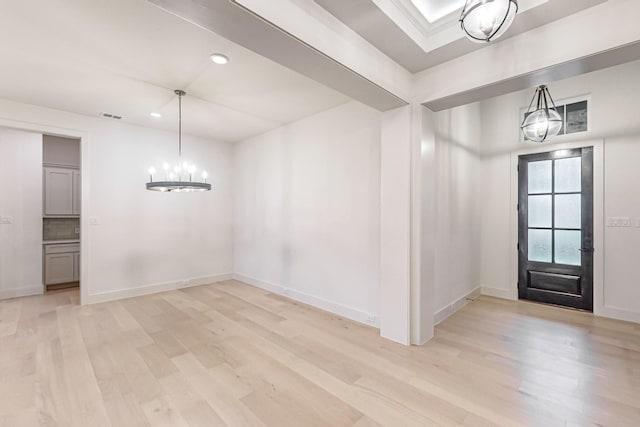 foyer entrance with light wood-style floors, a chandelier, visible vents, and baseboards