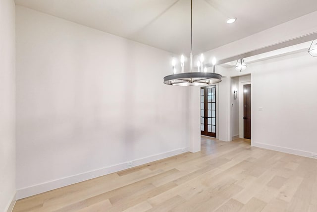 unfurnished dining area featuring baseboards and wood finished floors