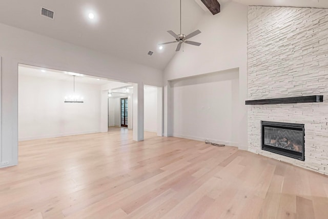 unfurnished living room with light hardwood / wood-style floors, high vaulted ceiling, a fireplace, beam ceiling, and ceiling fan