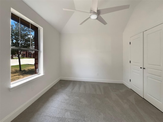 unfurnished bedroom featuring baseboards, a ceiling fan, lofted ceiling, carpet floors, and a closet