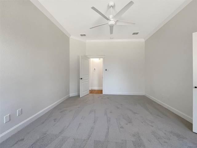 empty room featuring baseboards, ceiling fan, visible vents, and crown molding