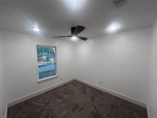 unfurnished room featuring ceiling fan and dark colored carpet