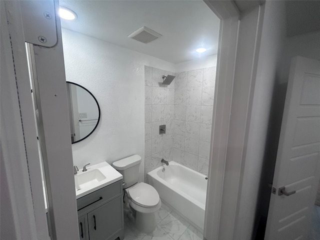 full bathroom featuring tiled shower / bath, vanity, and toilet