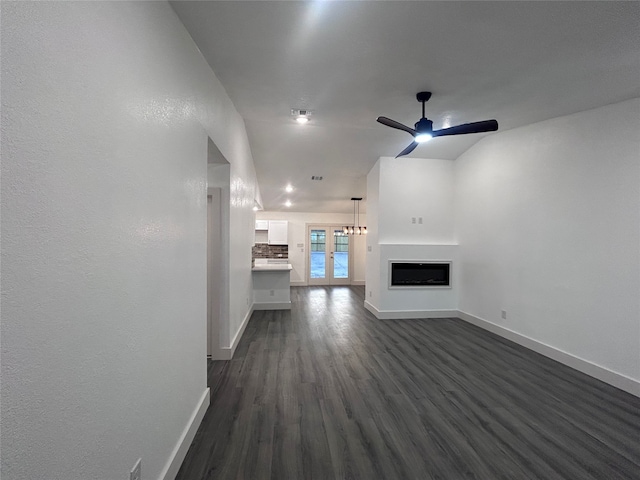 unfurnished living room with dark wood-type flooring and ceiling fan