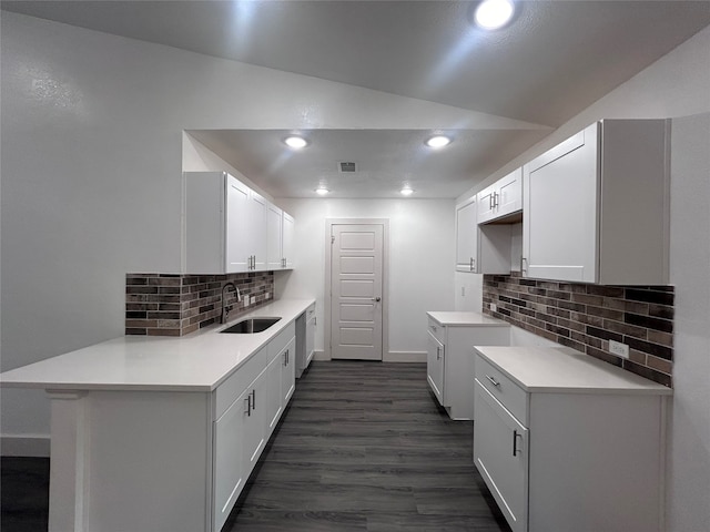 kitchen featuring vaulted ceiling, dark hardwood / wood-style floors, tasteful backsplash, sink, and white cabinetry