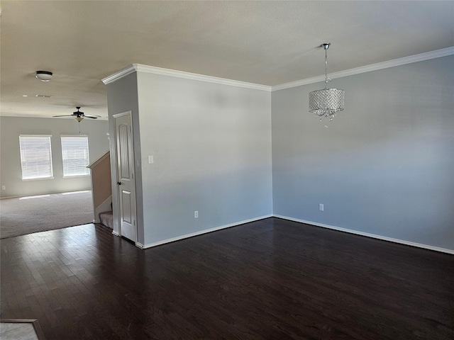 spare room featuring ceiling fan with notable chandelier, crown molding, and dark wood-type flooring