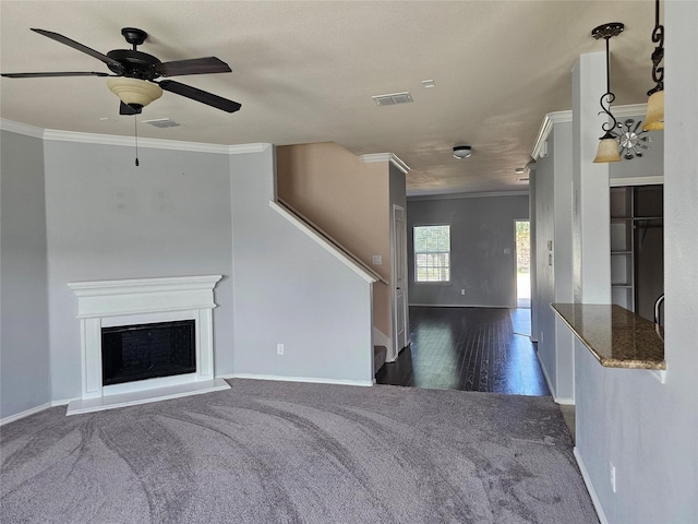 unfurnished living room featuring ceiling fan, crown molding, and dark hardwood / wood-style flooring