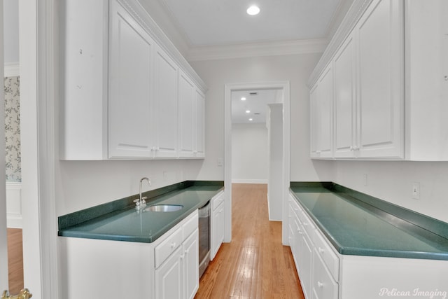 kitchen with white cabinets, ornamental molding, sink, and light hardwood / wood-style flooring