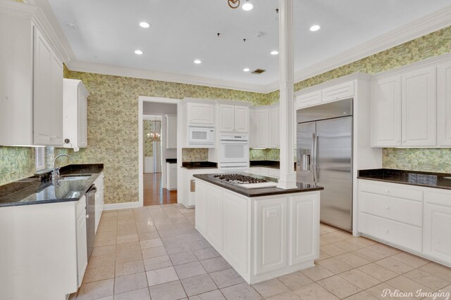 kitchen featuring built in appliances, light hardwood / wood-style floors, a center island, ornamental molding, and decorative backsplash