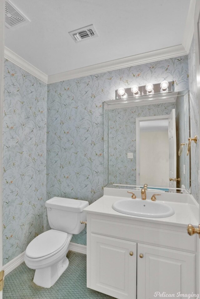 bathroom with toilet, crown molding, and vanity