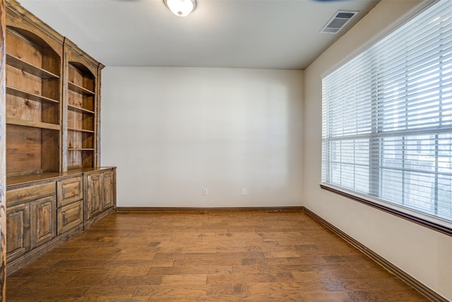 unfurnished room featuring dark hardwood / wood-style flooring and a healthy amount of sunlight